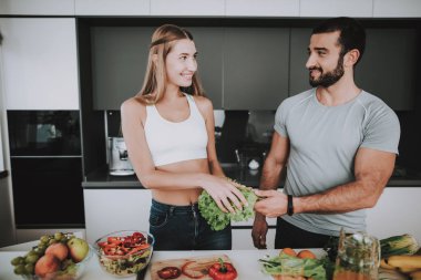 Bir çift bir salata bir kahvaltı için hazırlanıyor. Birlikte yemek... Sağlıklı bir yaşam tarzı. Genç ve yakışıklı. Spor vücut. Evin iç. Çanak doğrama. Sabah taze beslenme kavramı.