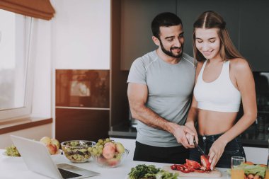 Bir çift bir salata bir kahvaltı için hazırlanıyor. Birlikte yemek... Sağlıklı bir yaşam tarzı. Genç ve yakışıklı. Spor vücut. Evin iç. Çanak doğrama. Sabah taze beslenme kavramı.