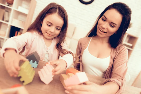 Mujer sonriente y niña con cubos de colores en las manos —  Fotos de Stock