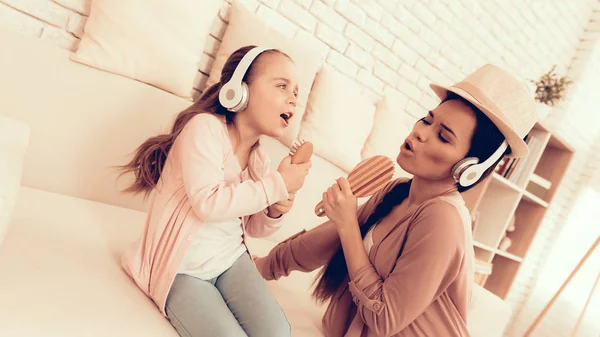 Chica y mujer en auriculares cantando en casa . —  Fotos de Stock