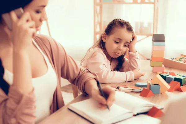 Triste menina e mãe com telefone em casa . — Fotografia de Stock