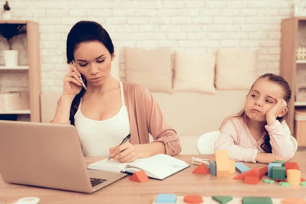 Triest klein meisje en moeder het werk op Laptop thuis. — Stockfoto