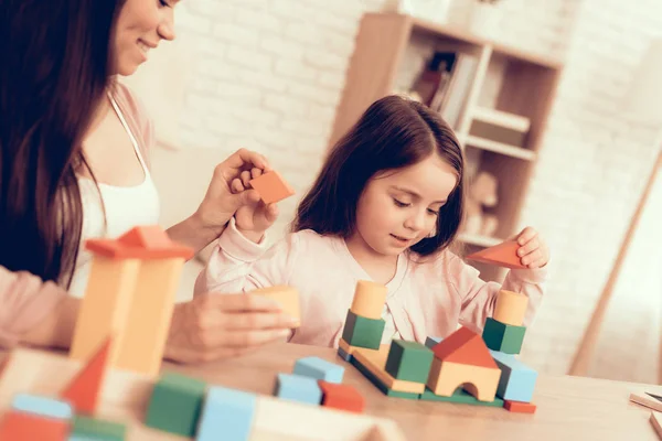Mulher e menina construir casa cubos coloridos na mesa . — Fotografia de Stock