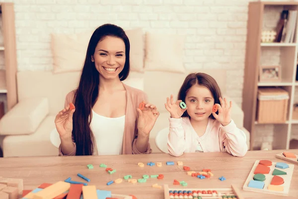 Mulher e menina sentadas com números de brinquedo em mãos . — Fotografia de Stock