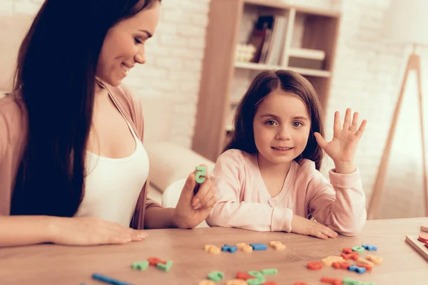 Mãe e menina com números de brinquedo aprendem a contar em casa . — Fotografia de Stock