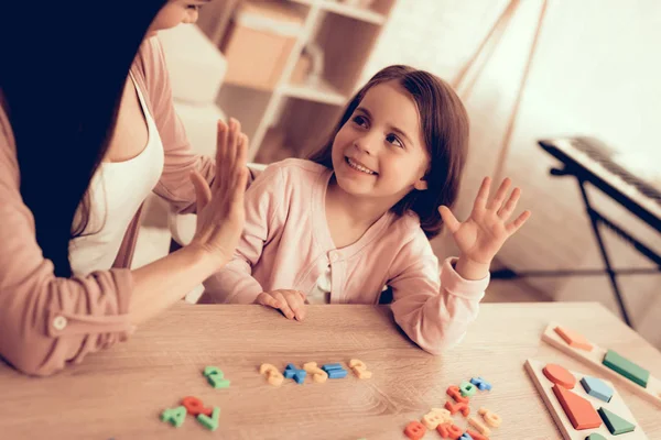 Donna e ragazza con numeri di giocattoli colorati sul tavolo . — Foto Stock