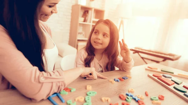 Mulher e menina sorridente aprendem números em casa . — Fotografia de Stock