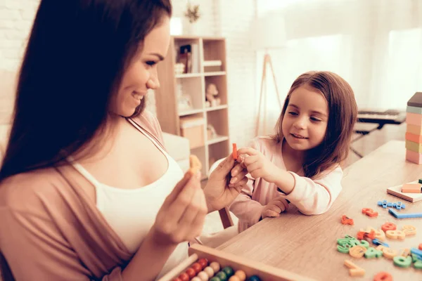 Mulher e menina sorridente aprendem alfabeto em casa . — Fotografia de Stock
