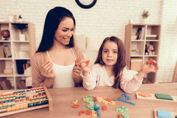 Mãe e filha felizes aprendem alfabeto em casa . — Fotografia de Stock