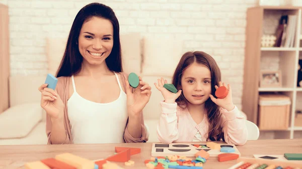 Mulher e menina Stting na mesa com cubos em mãos — Fotografia de Stock