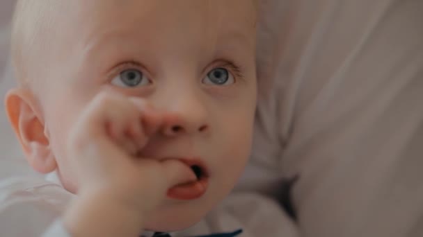 Een kleine baby die aan zijn duim zuigt. Close-up portret van een kind. Gelukkige jeugd. — Stockvideo