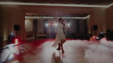 Sis ve dumanla çevrili bir çiftin dansını.