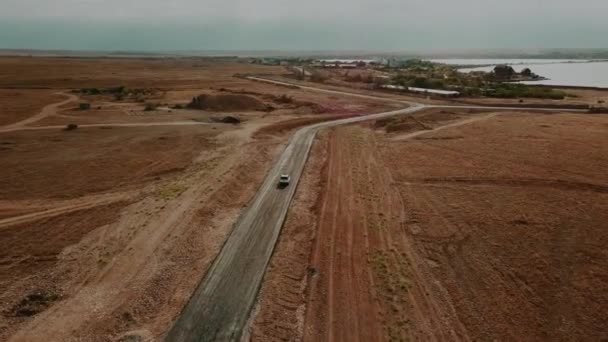 Giro in auto attraverso il deserto su un'autostrada deserta vuota verso il mare. Aerea — Video Stock