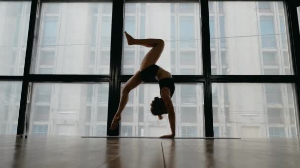 Menina ruiva bonita fazendo ioga e fitness em estúdio na janela de fundo — Vídeo de Stock