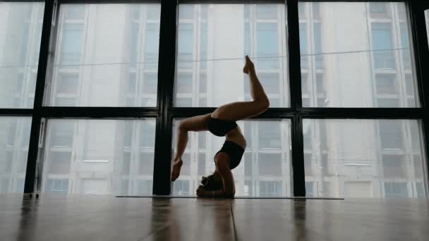 Chica pelirroja bonita haciendo yoga y fitness en el estudio en la ventana de fondo — Vídeo de stock
