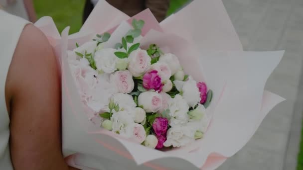 Primer plano de un gran ramo de flores en una mano femenina. Chica sostiene un ramo . — Vídeos de Stock