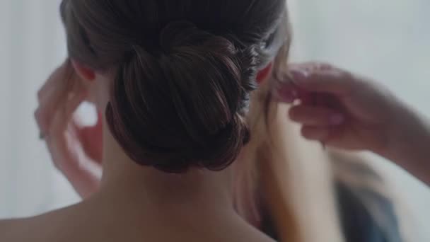 Bun účes zblízka. Účes a make-up pro brunetky ženy. — Stock video
