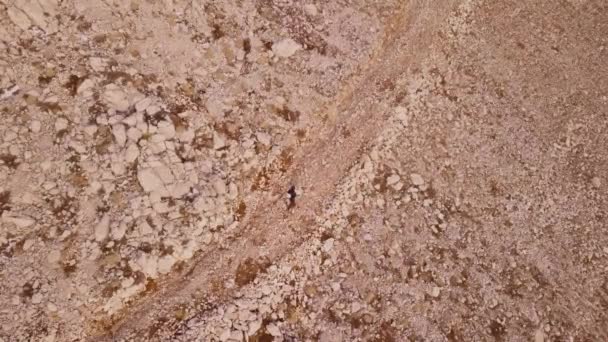 Un homme traverse une zone rocheuse déserte. La Terre après l'Apocalypse. Vue aérienne du dessus