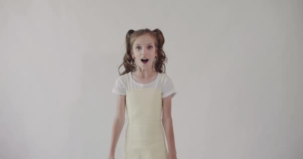 Młoda emocjonalna dziewczyna zaskoczona i zszokowana na białym tle. Izolacja. — Wideo stockowe