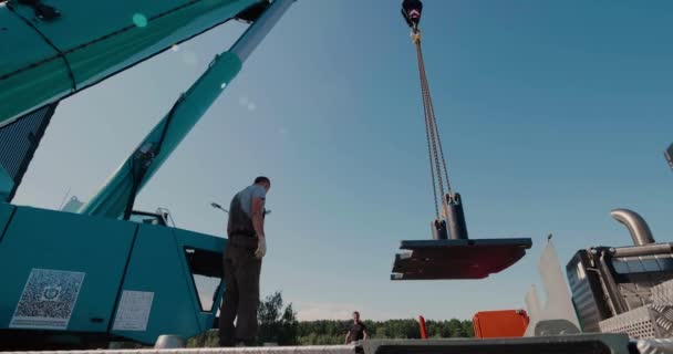 Weißrussland, Minsk - 30. Juli 2020: Bauarbeiter montieren ein Gegengewicht auf einem Autokran. Linsenschlag. — Stockvideo