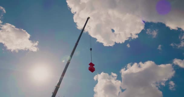 Una cuna de edificio naranja levantada por una grúa móvil se levanta. — Vídeos de Stock