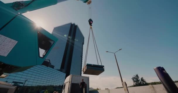 Cabin och bom av en lastbil kran flyttar lasten mot bakgrunden av himlen — Stockvideo