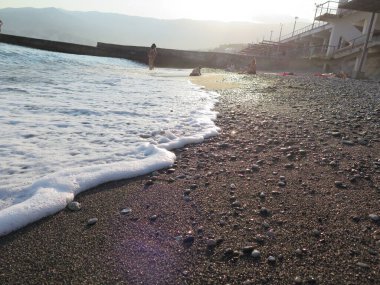 Gün batımında dalgalar kıyıya vurur.