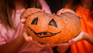 Balkabağı Jack çocuğun elinde. Cadılar bayramı için balkabağını dikkatlice koruyun.