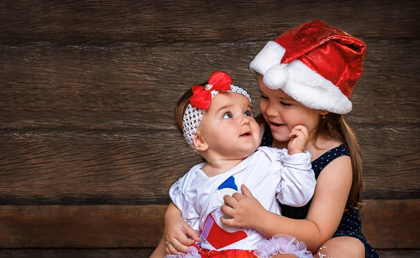 Crianças Meninas Natal Bonés Papai Noel Fundo Madeira Irmã Mais — Fotografia de Stock