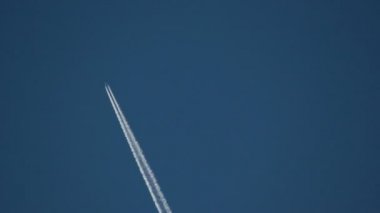 Yüksek irtifada hızlı bir şekilde geçen ticari uçak arkalarında contrails bırakarak