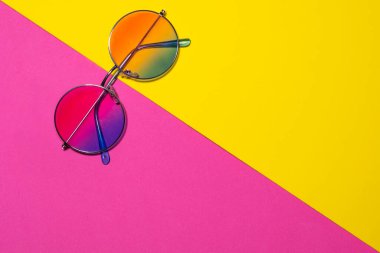 Sarı ve pembe arkaplanda izole edilmiş moda güneş gözlükleri