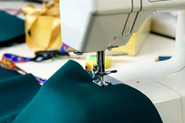 テーブルの上にミシン 前景に緑の布 接近中だ コンセプト 趣味で縫製 — ストック写真