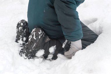 Çocuk karda, tarlada, çayırda, ölü ağaçta yürüyor. Sıcak ceket, kışlık gri eldivenler. Karda dizlerinin üstünde oturuyor..