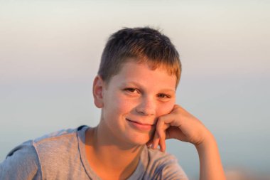 Gülümseyen bir çocuğun portresi, yakın çekim, bronzlaşma, akşam fotoğrafı..