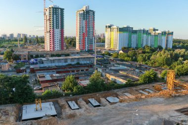 Şantiyeli manzara, garajlar ve gün batımında yeni evler