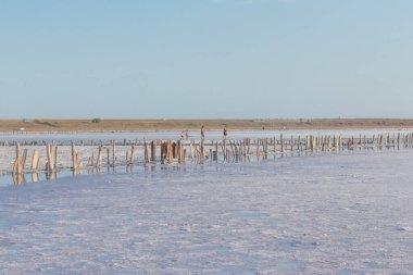 Mavi tuz gölü, gün batımında terk edilmiş bir tuz fabrikasının yanında.
