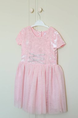 Askıda asılı şık çocuk elbisesi dolabın sapında asılı..