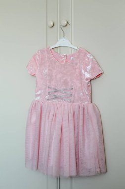 Askıda asılı şık çocuk elbisesi dolabın sapında asılı..