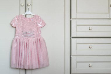 Askıda asılı şık çocuk elbisesi dolabın sapında asılı..