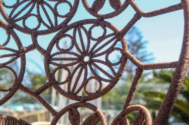 Bir Yunan otelinin terasında hasır bir sandalyenin arkasında..