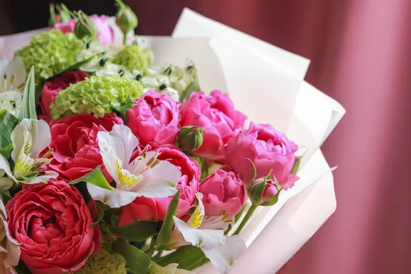 Pink-green bouquet of roses, white lilies, hydrangeas on a purple background