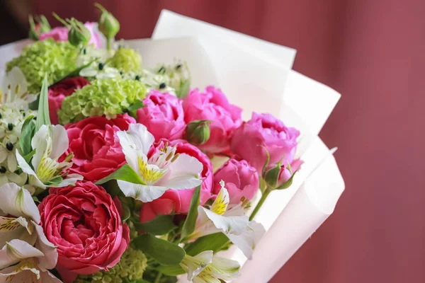 Pink-green bouquet of roses, white lilies, hydrangeas on a purple background