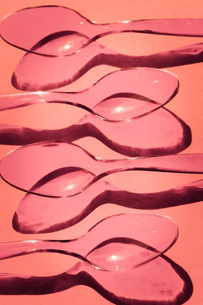 Colheres Plástico Descartáveis Fundo Rosa Com Sombras Contrastantes — Fotografia de Stock