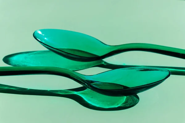Två Gröna Transparenta Plastskedar Med Kontrasterande Skuggor — Stockfoto