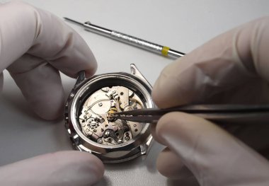 antika kronograf saati üzerinde çalışan saatçiyi kapat