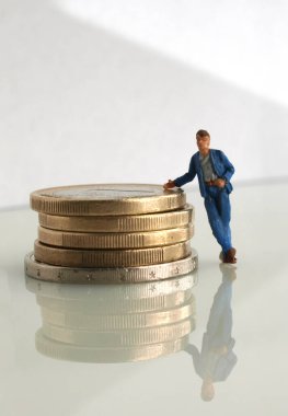 Meşguliyet başarısı kinayesi: İşçilerden oluşan minyatür bir oyuncak altın para yığınının yanında, 