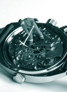 Vintage saat makinesinin üzerinde küçük oyuncak işçi figürü: zaman para kavramıdır            