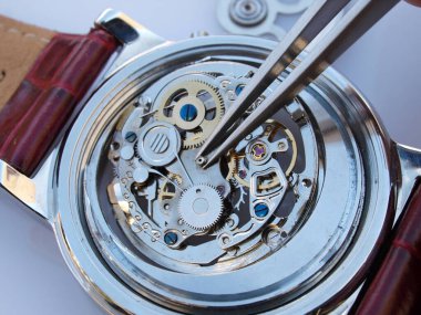 Eski mekanik saat kalibrelerini tamir eden saatçiye yaklaşıp cımbızla küçük bir parça alıyorum.        