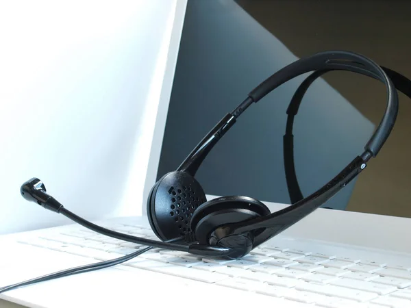 online communication: headphone set over laptop keyboar
