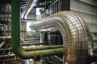 Enerji santralinin kazanında termal yalıtımlı buhar boruları. 